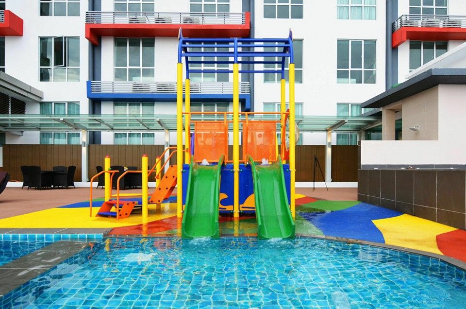 Colourful children's water play area with slides and a shallow pool at a JB hotel