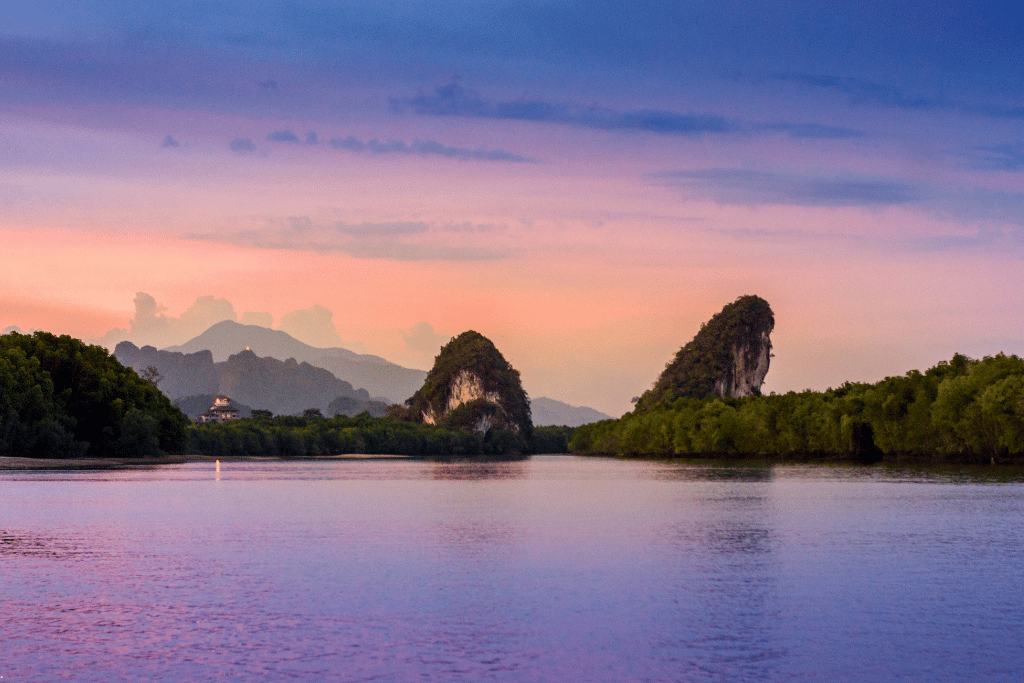 Two limestone karsts on the Krabi River under a pink dusk sky
