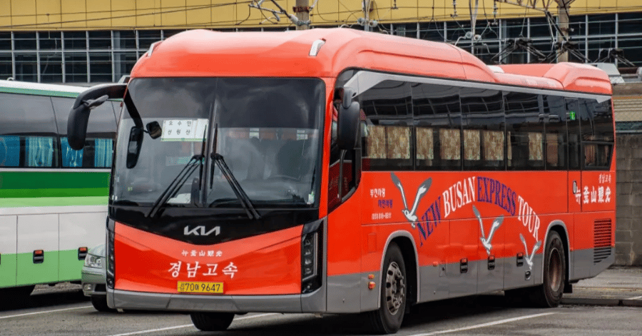 A red Korean express coach bus parked at a terminal