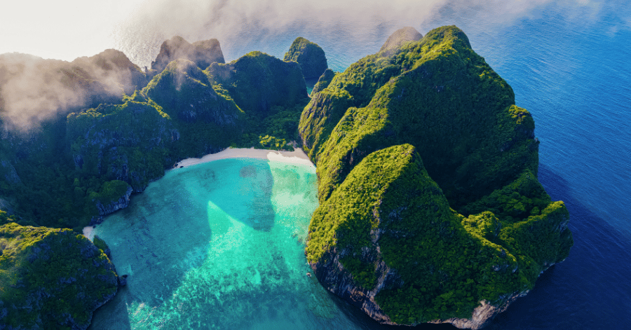 Aerial view of Maya Bay's white-sand cove ringed by green cliffs, Phi Phi Islands