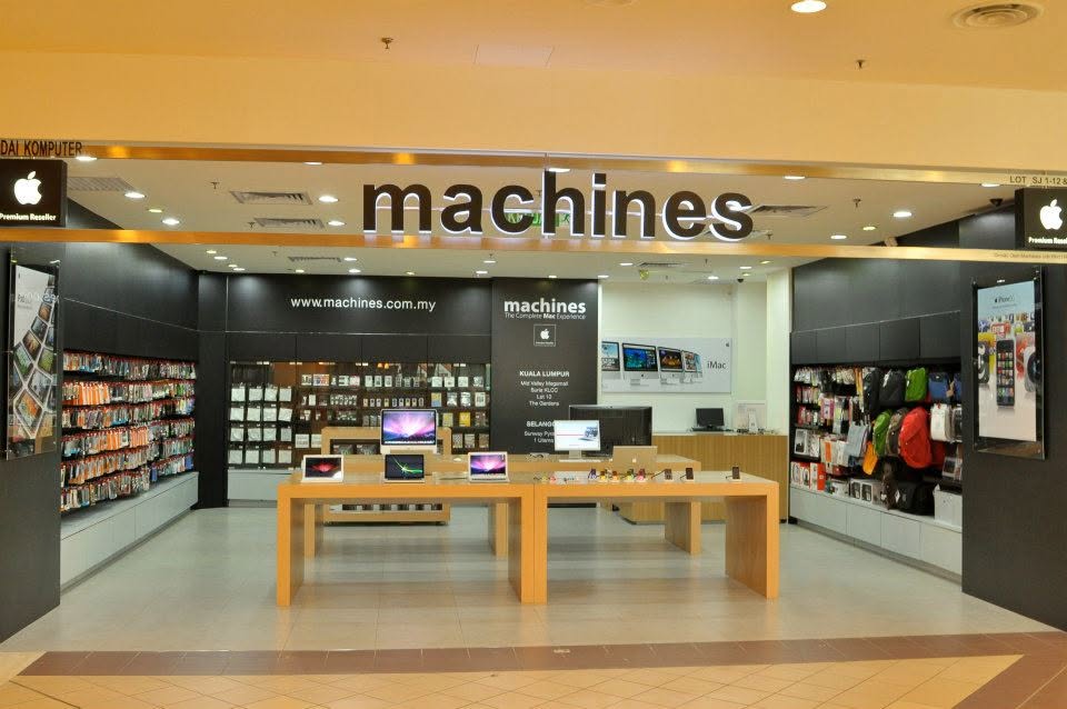 The Machines Apple Premium Reseller storefront with laptops on display tables