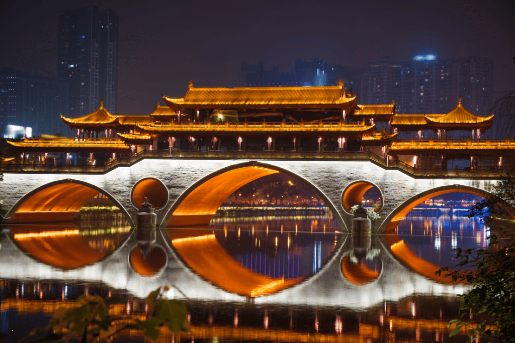 Anshun Bridge lit gold at night and reflected in the river, Chengdu