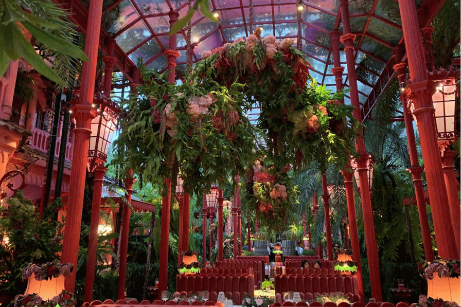 The red-columned, greenery-draped conservatory interior of Rose Villa Saigon