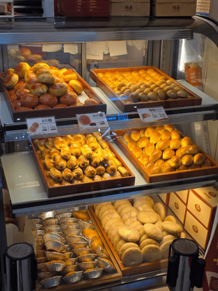 Display cases of traditional buns, pastries and tarts at Ming Ang Confectionery