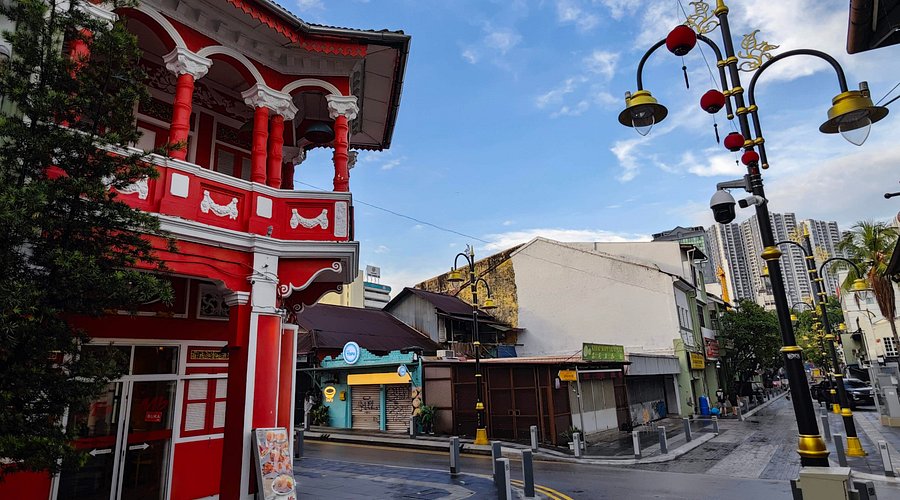 A restored red heritage shophouse on a quiet street in Johor Bahru's old town