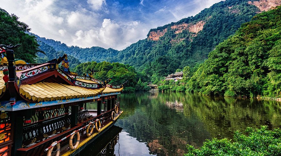 A traditional boat on a forest-ringed lake at Mount Qingcheng near Chengdu
