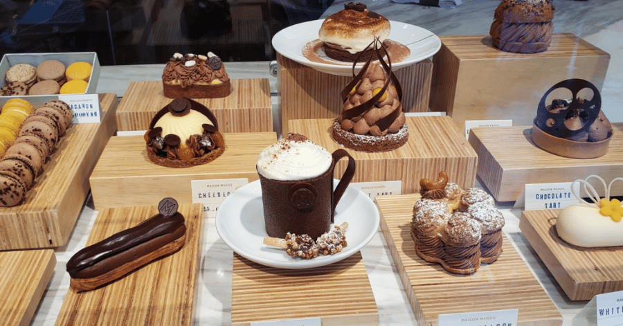 A hot chocolate and chocolate pastries on display at Maison Marou