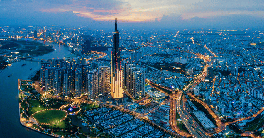 Aerial view of Ho Chi Minh City at dusk with Landmark 81 towering over the river