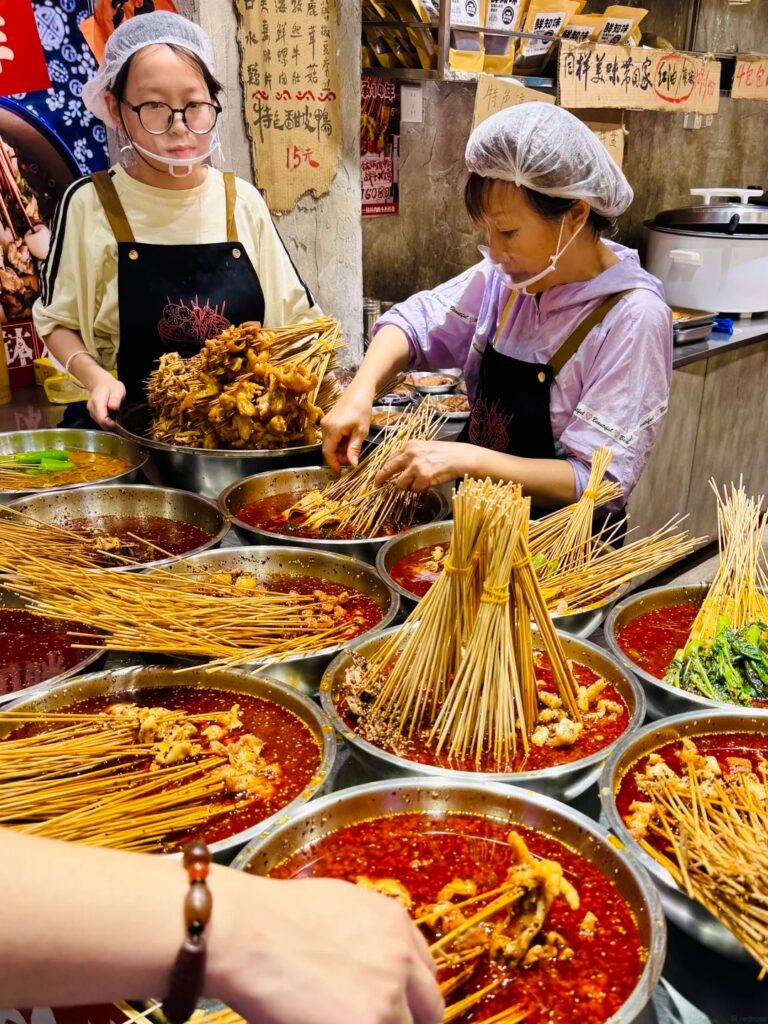 Cold skewers of bo bo chicken in a spicy, numbing broth