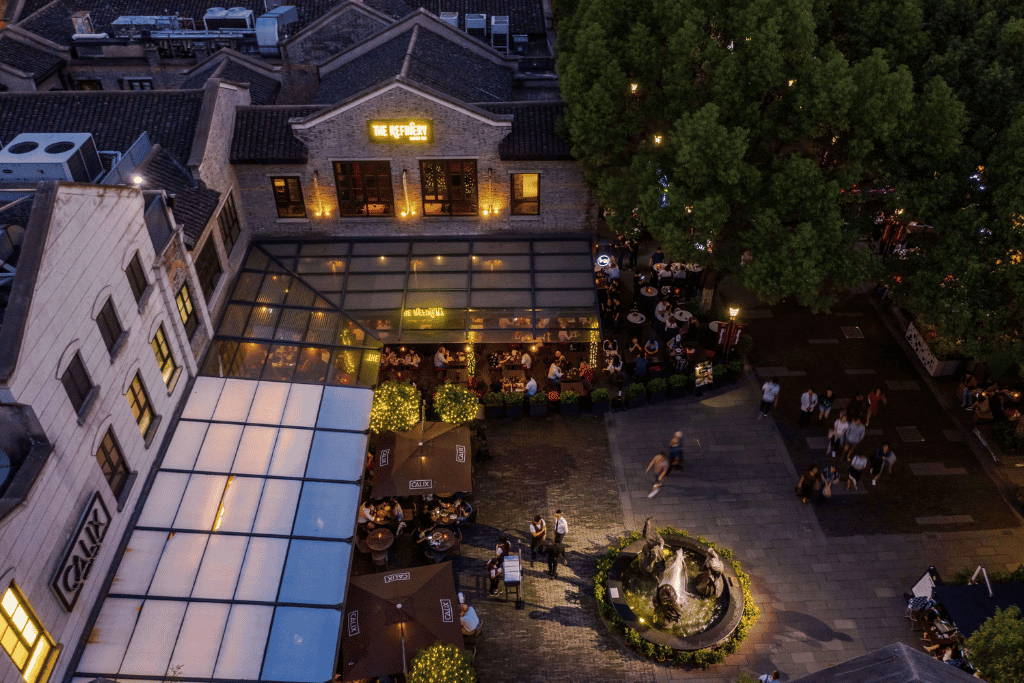 Aerial dusk view of Xintiandi's restored lane houses with outdoor diners lit below