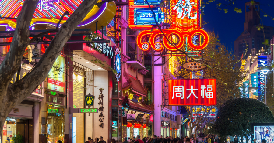 A busy Shanghai shopping street glowing with neon signs at night