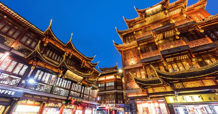 Traditional tiered Chinese rooftops of Shanghai's Yuyuan old town glowing gold at night