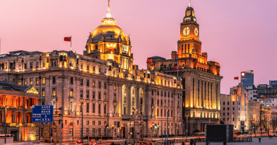 The Bund's grand 1920s colonial buildings and clock tower lit at dusk in Shanghai