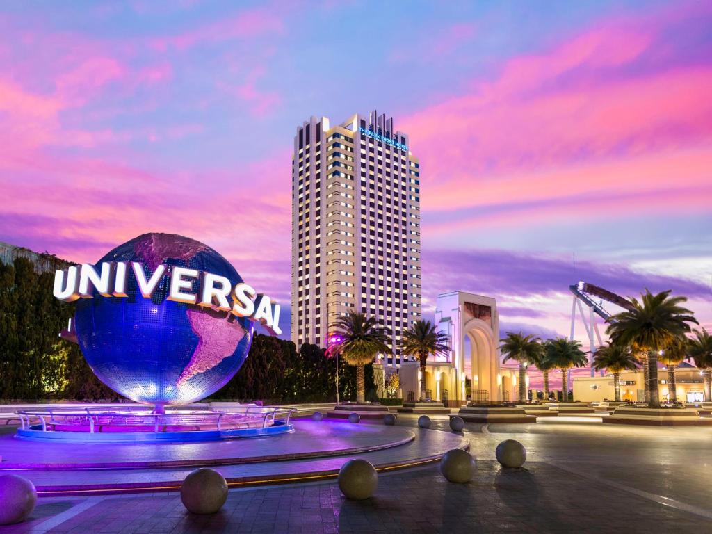 The Universal globe fountain at sunset with a Universal City hotel tower behind
