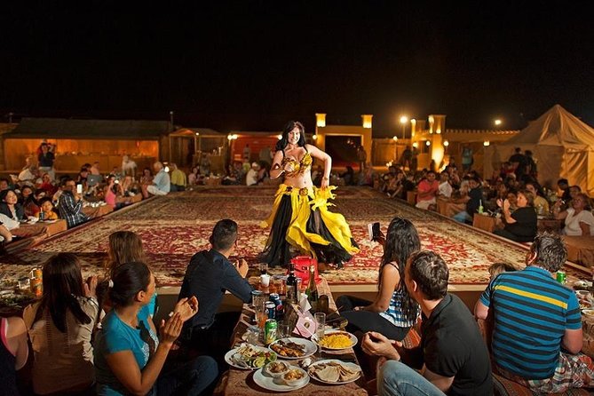 Belly dancer performing for diners at a desert safari camp in the evening