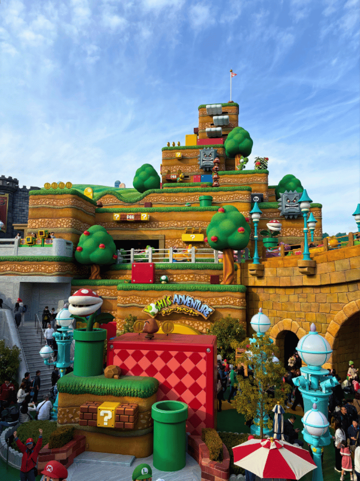 Super Nintendo World's tiered Mario mountain with question blocks, warp pipes and a Piranha Plant