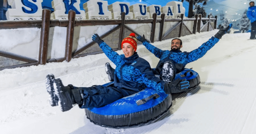 Two people snow tubing on the indoor slope at Ski Dubai