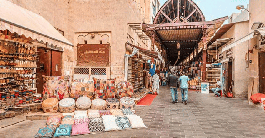 A narrow shopping street lined with textile and souvenir stalls at Meena Bazaar