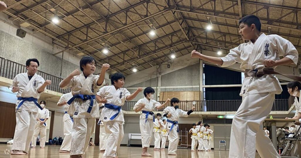 Students in white gi practising karate stances at Okinawa Karate Kaikan