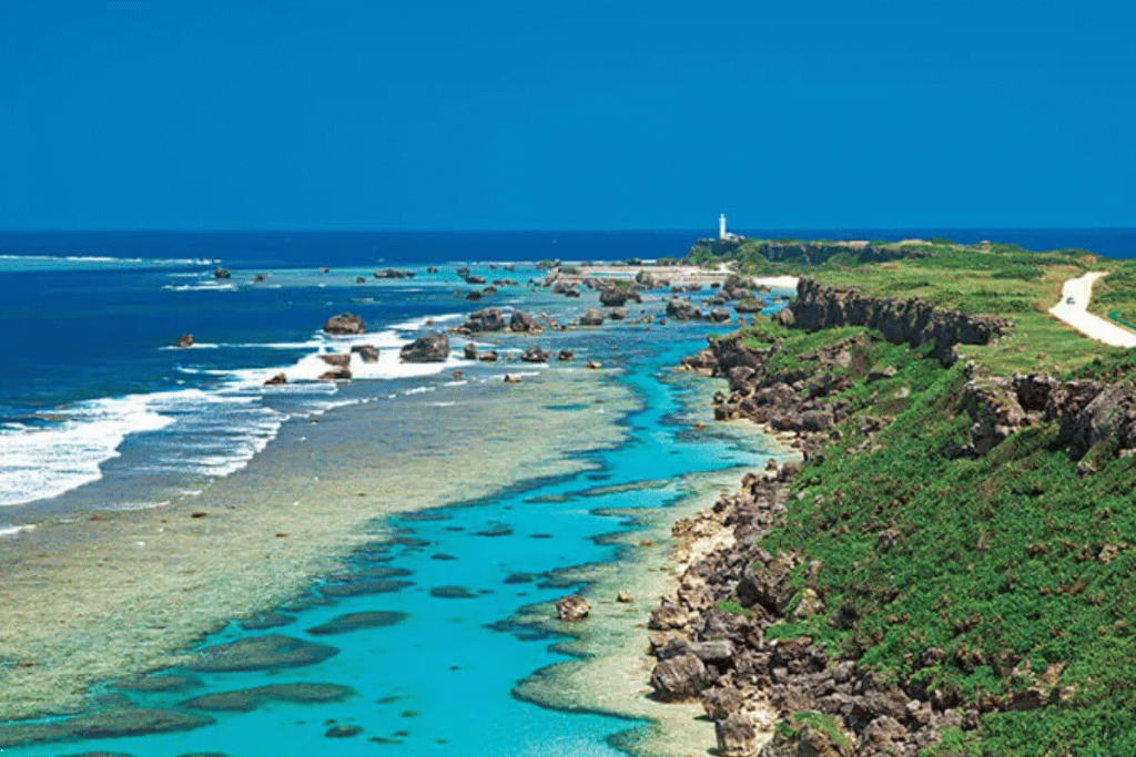 Miyako Island's rocky coastline with turquoise water and a distant lighthouse