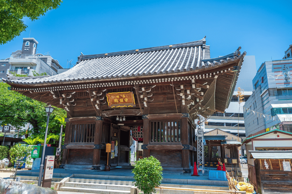 The wooden entrance gate of Kushida Shrine in Hakata under a clear blue sky