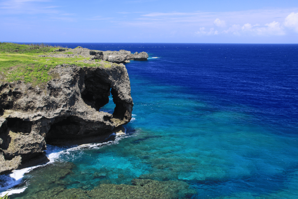 Cape Manzamo's elephant-trunk-shaped cliff jutting into turquoise ocean water