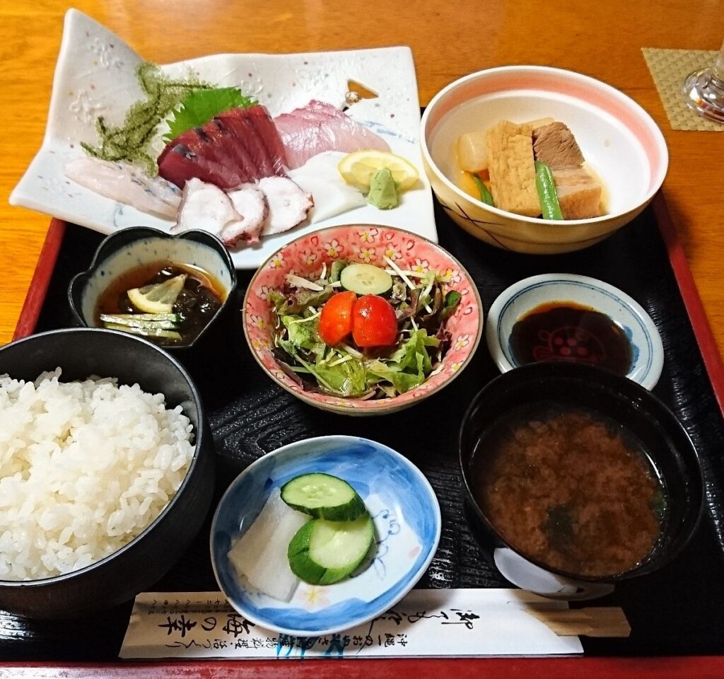 A seafood set meal with sashimi, rice and side dishes at Uminosachi