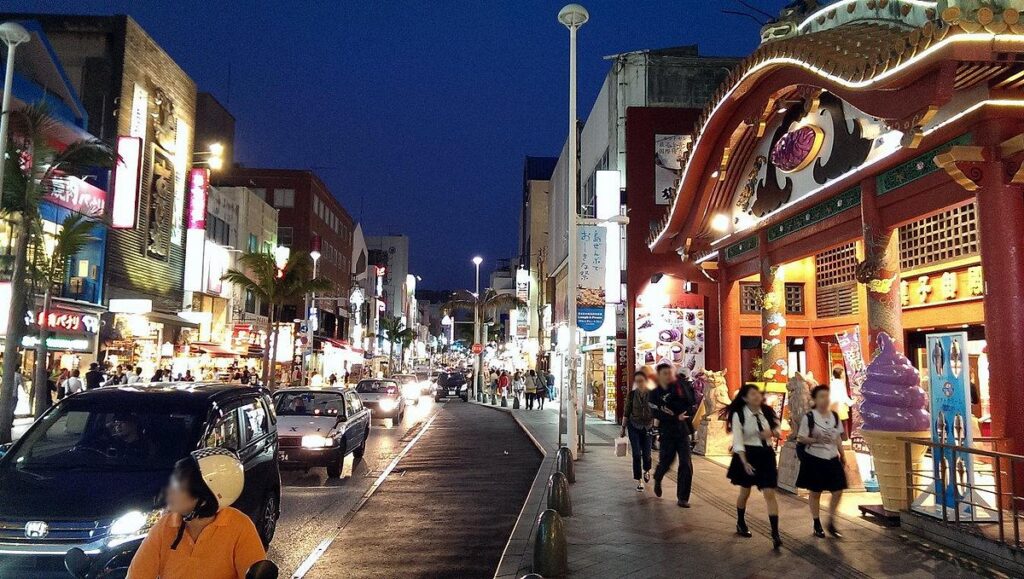Kokusai Dori shopping street in Naha lit up with shops and pedestrians at night