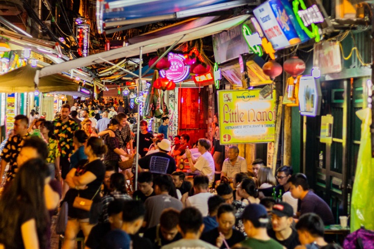 Drinkers on low plastic stools packed along Ta Hien Street in Hanoi's Old Quarter