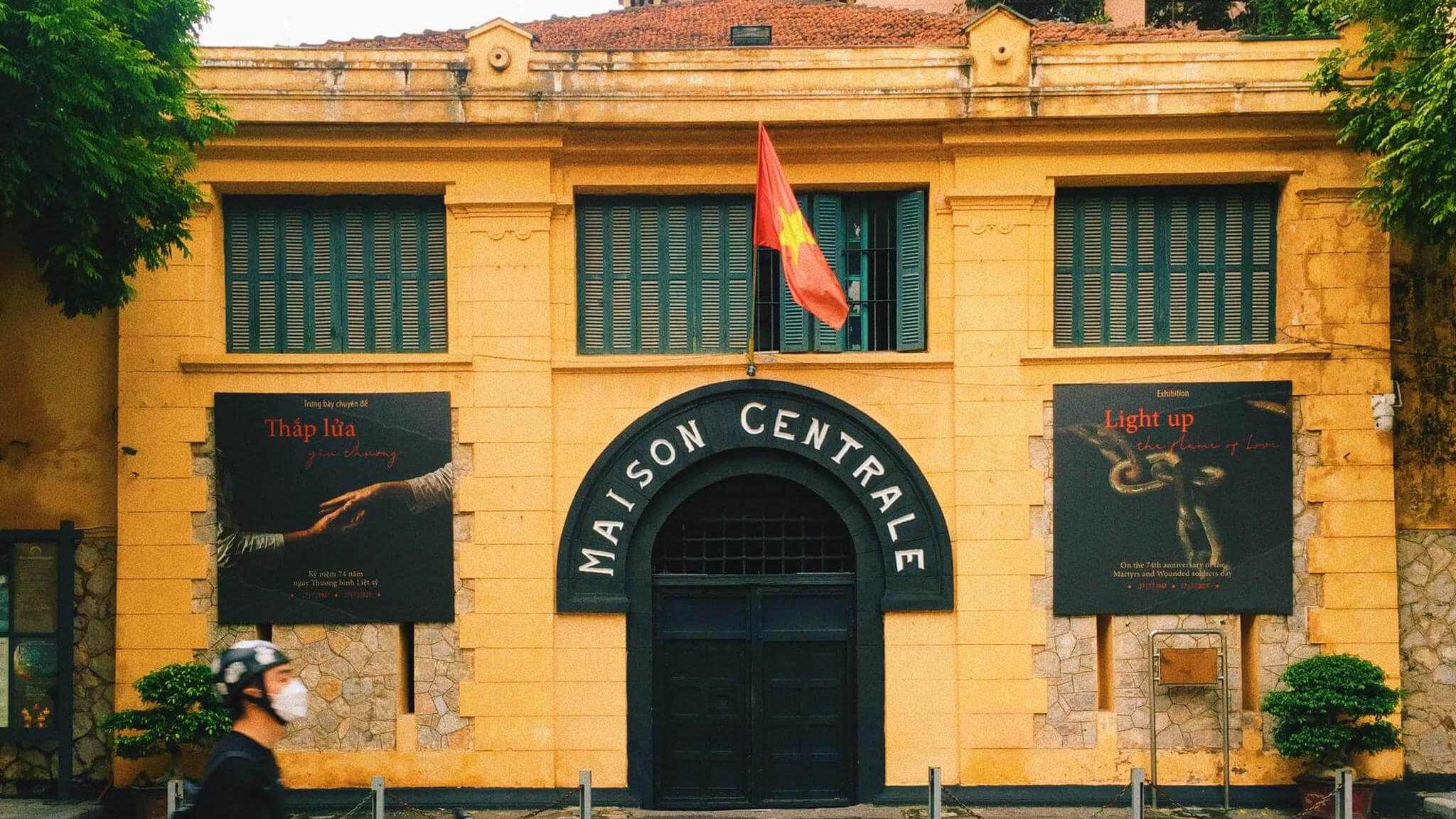 Yellow colonial facade and barred gate of Hoa Lo Prison in Hanoi