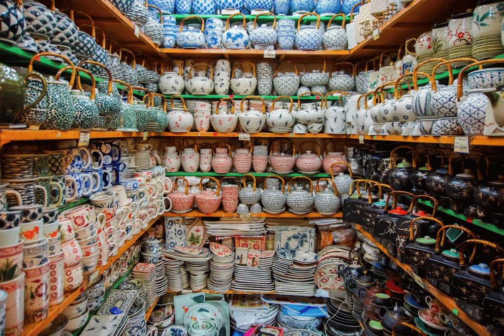 Shelves stacked with blue and white ceramic teapots, bowls and mugs at a Bat Trang workshop