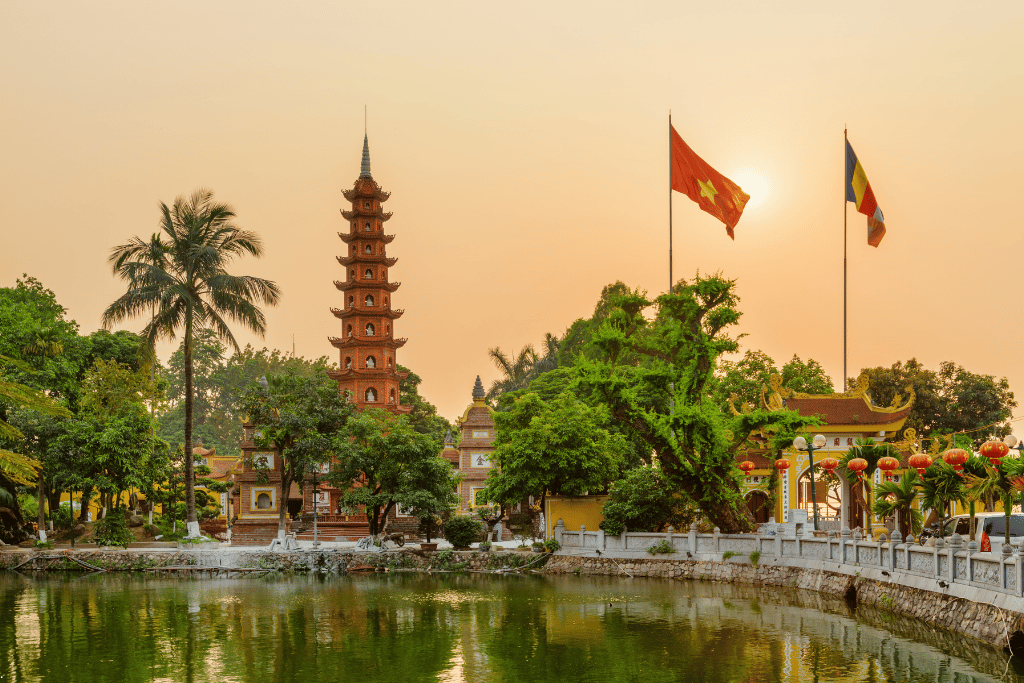 Red eleven-tier stupa of Tran Quoc Pagoda beside West Lake at sunset