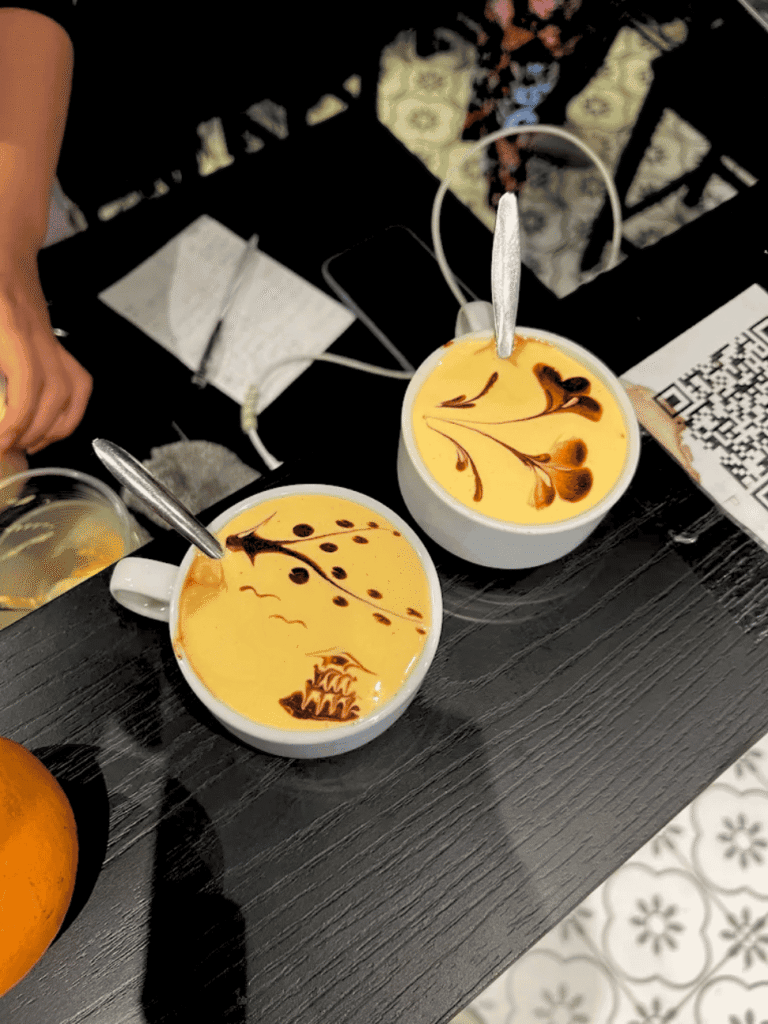 Two cups of golden egg coffee decorated with swirled chocolate patterns