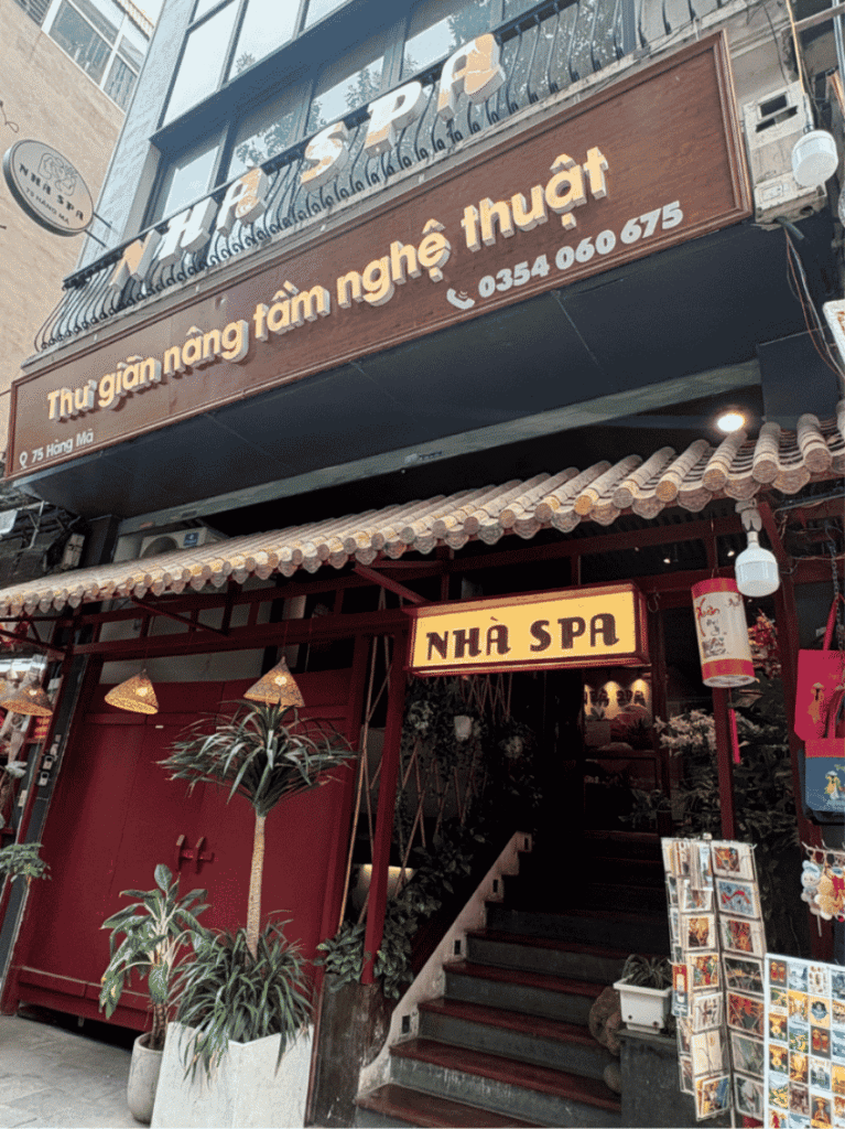 Red and timber shopfront of Nha Spa on Hang Ma with lanterns and potted plants