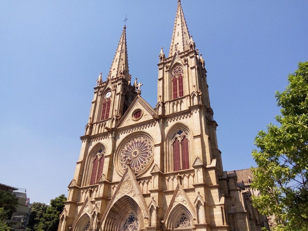 The twin granite Gothic spires of the Sacred Heart Cathedral against a blue sky in Guangzhou