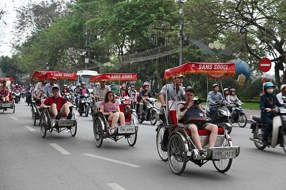 Three-wheeled cyclo with its driver waiting on a Hanoi street