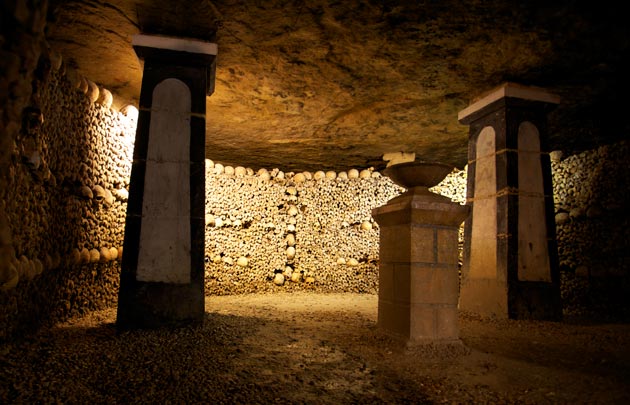 A chamber in the Catacombs of Paris lined floor to ceiling with stacked bones