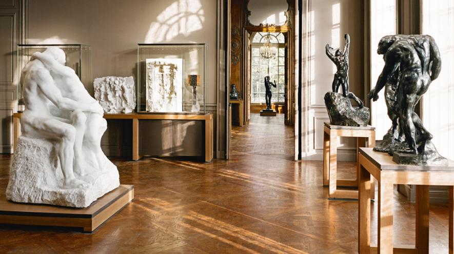 Rodin sculptures including The Kiss displayed inside a sunlit gallery at Musée Rodin