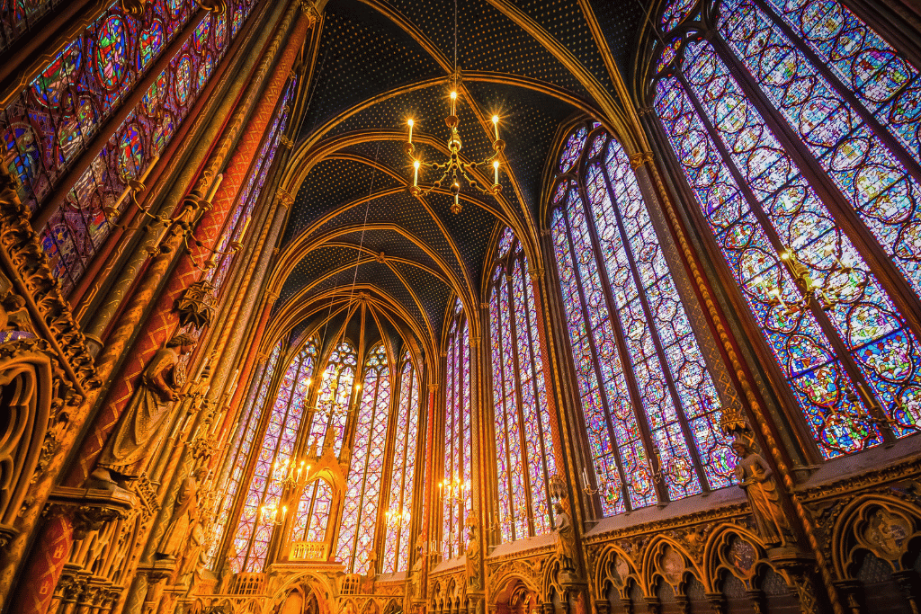 Sainte-Chapelle's upper chapel with towering stained-glass windows and a gold chandelier
