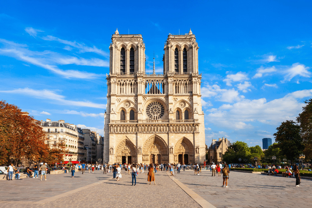 Notre-Dame Cathedral's restored Gothic facade with visitors gathered in the square outside