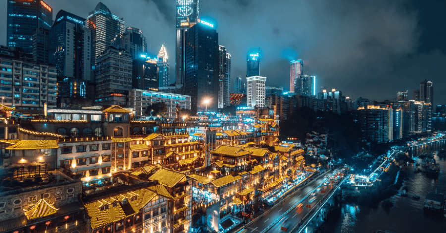 Hongyadong glowing beside Chongqing's modern skyline at night