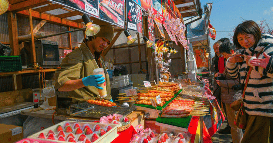 Vendor serving snacks at a Japanese summer festival street food stall