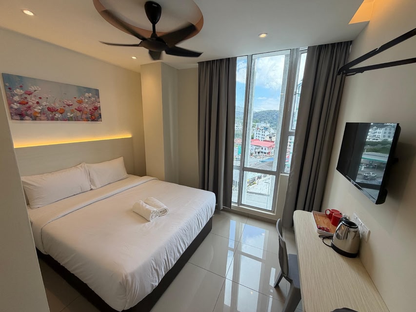 Budget hotel room with a double bed, ceiling fan and town-view window near Cameron Centrum