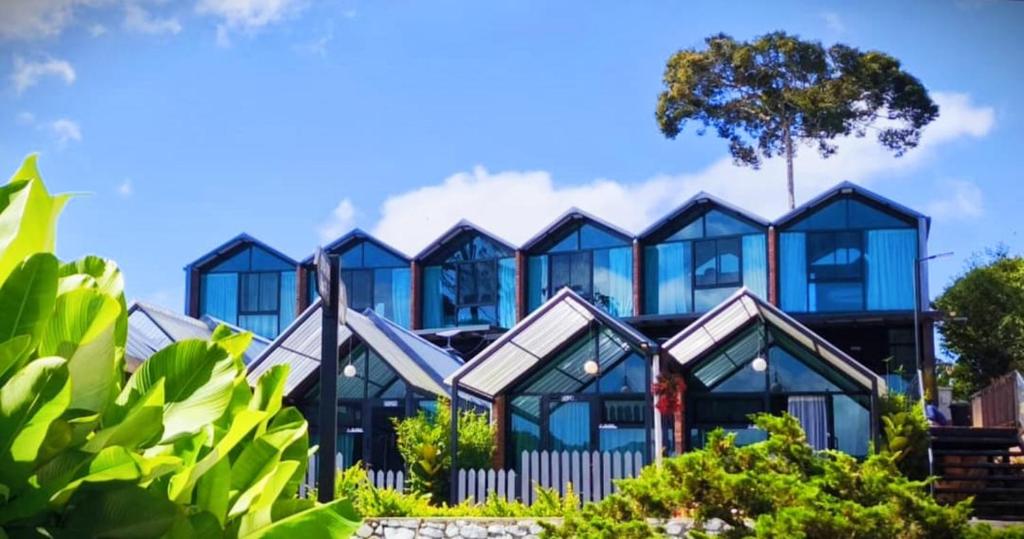 Rows of glass-fronted A-frame pod cabins on a hillside at Campod Resort, Brinchang