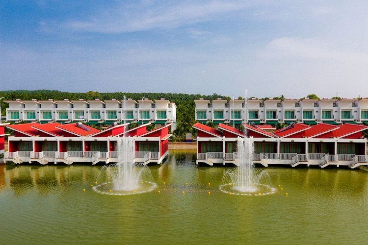 Red-roofed villas lining a lake with fountains at Tasik Villa resort
