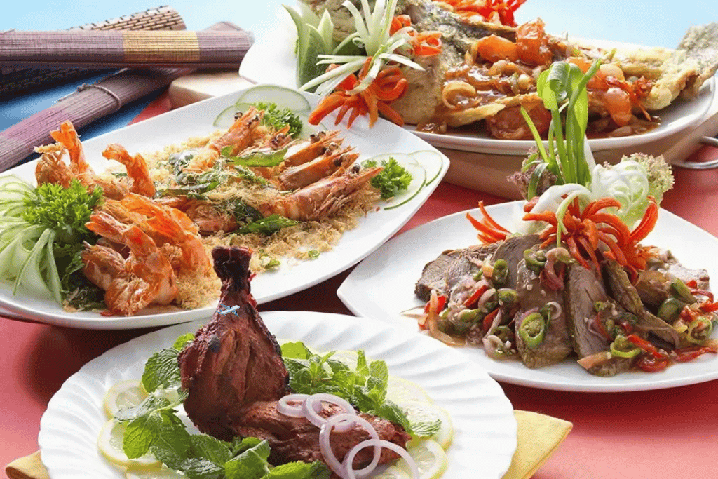 Table spread of Malaysian seafood dishes including prawns, fish and greens