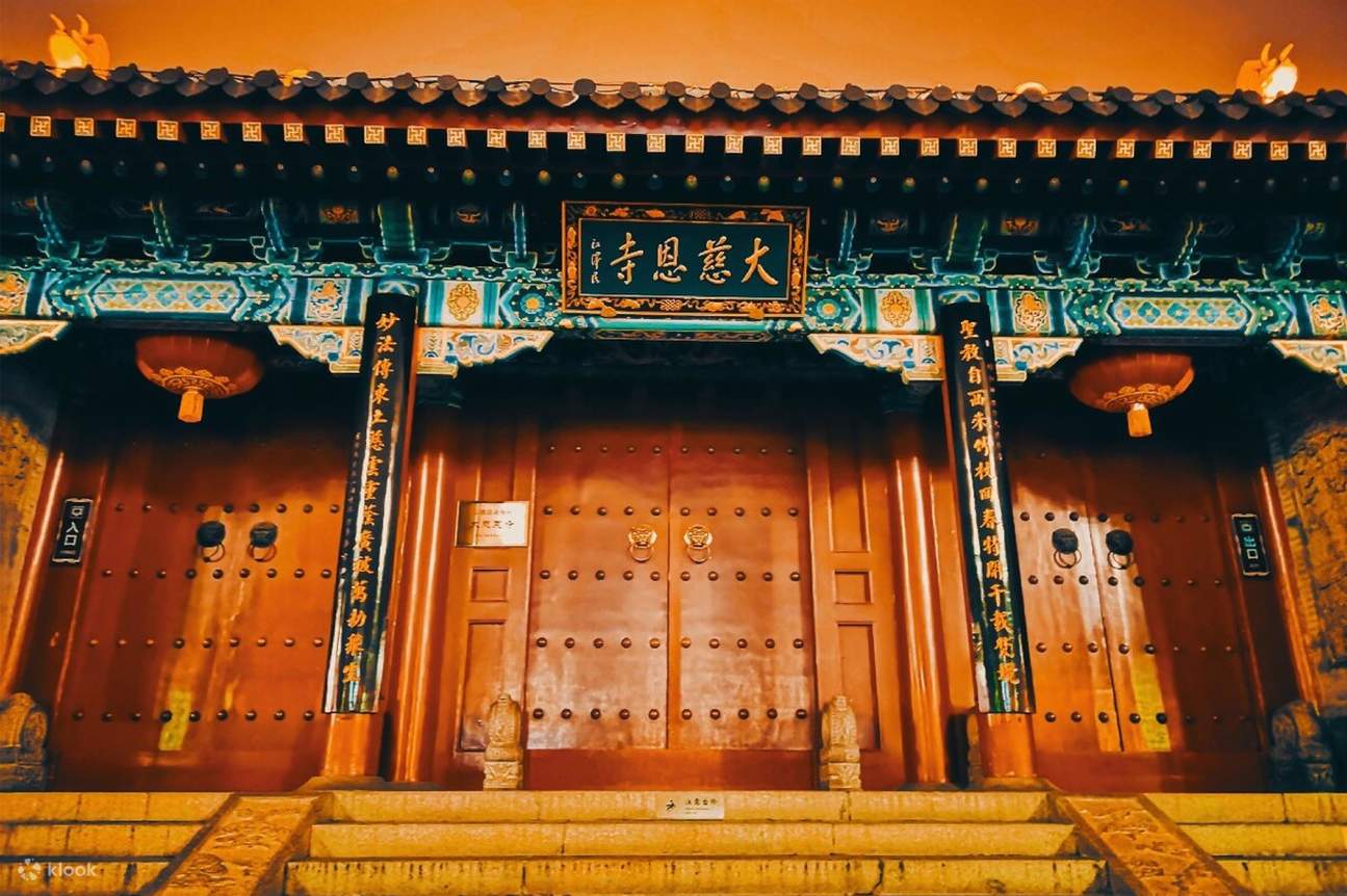The red entrance gate of Da Ci'en Temple lit at night with its name plaque