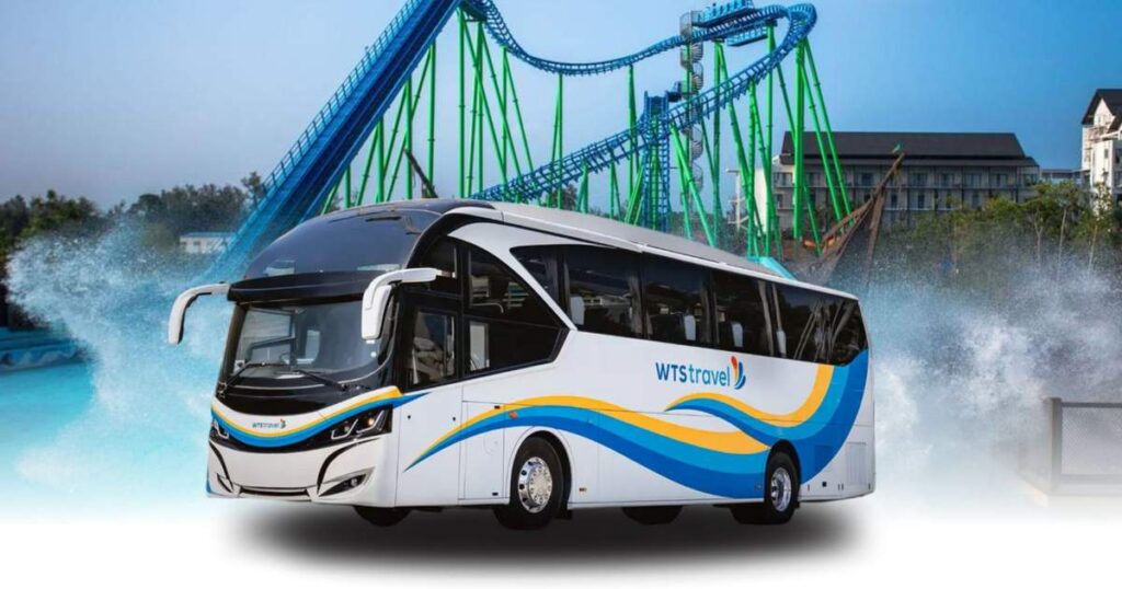 A white WTS Travel coach in front of the roller coaster and pools of Desaru Coast Adventure Waterpark