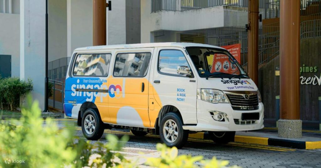A white Singapool community-ride minivan parked under a building, used for door-to-door transfers