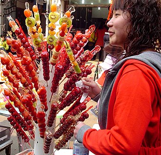 A street vendor's rack of colourful tanghulu candied fruit skewers
